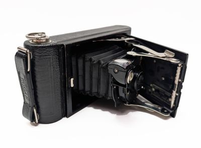 an old black camera with its open case open