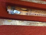 trois vieilles battes de baseball en bois posées sur un tapis rouge