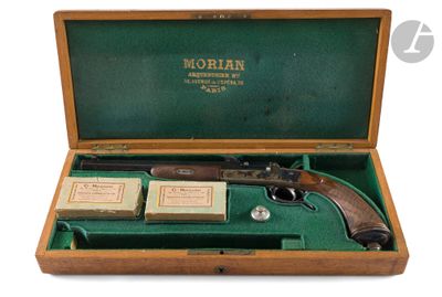 un vieux pistolet dans un coffret en bois, avec une boîte de cartes