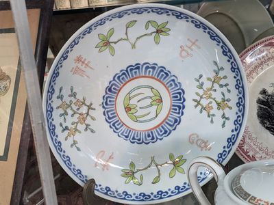 many plates and cups that are on display in a glass case