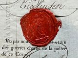 a red wax seal on top of a piece of paper