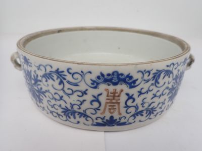 un vieux bol bleu et blanc sur lequel figure une inscription en chinois