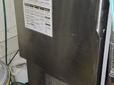une photo d'une cuisine avec un réfrigérateur et une poubelle