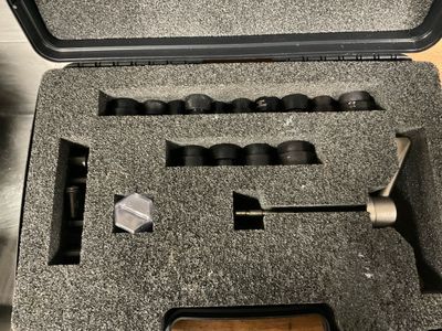 une mallette noire contenant des outils, posée sur une table