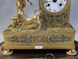 a gold clock with a statue on top of it