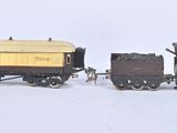 deux petits trains miniatures posés sur une surface blanche