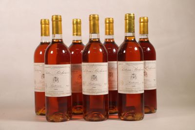 quatre bouteilles de vin sont alignées sur une surface blanche