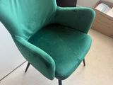 une chaise verte qui se trouve dans un coin de la pièce
