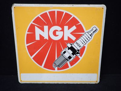 une pancarte sur laquelle est inscrit « ngk » sur fond noir