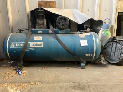a blue compressor sitting on the ground in front of a building