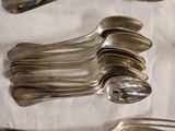 a lot of silver spoons and spoons on a table