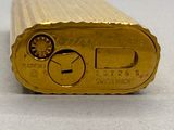 a close up of a gold cigarette lighter on a table