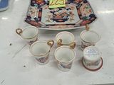 several cups and saucers are sitting on a table in a room
