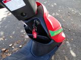 a red and black scooter parked on the side of the road
