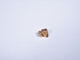 a small piece of gold on a white surface