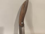 the knife is sitting on top of a piece of wood
