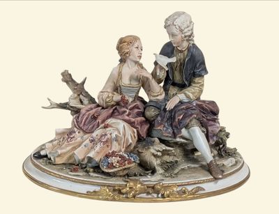 a figurine of a man and a woman sitting on a rock