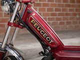 a close up of a red motorcycle parked in front of a brick wall