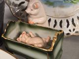 a figurine of a cat in a box next to a plate