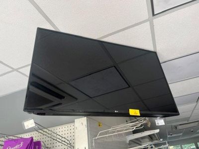 un téléviseur à écran plat suspendu au plafond dans un magasin