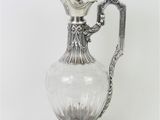 un pichet ancien en verre plaqué argent, muni d'une anse, sur fond blanc