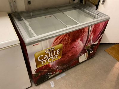 a large ice cream machine sitting in the corner of a kitchen