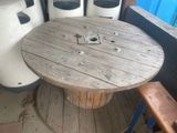 une bobine en bois posée sur une autre bobine, sur une table en bois