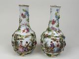 une paire de vases en porcelaine ornés de personnages peints, posés sur une table