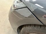 a close up of a car ' s front bumper with a denting on it