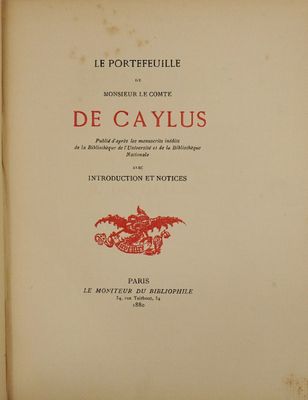 un vieux livre orné d'un dragon rouge, posé sur une table
