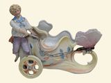 a figurine of a boy riding a carriage