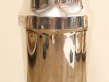 a silver container sitting on a table with a white wall in the background
