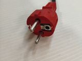a red plug with a black wire on a white surface