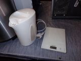 a white kettle sitting on a table next to a digital scale
