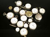 many different types of pocket watches on a black surface