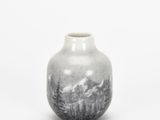 a small vase with a picture of a mountain scene on it