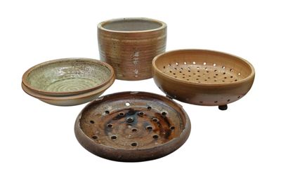 three bowls and a strainer on a white background