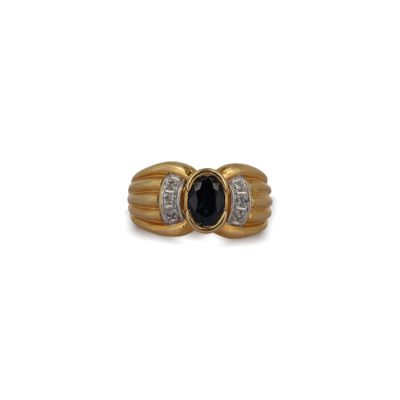 gros plan d'une bague en or avec une pierre noire