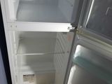 an open refrigerator with the door open on a wooden floor