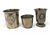 three silver cups with designs on them sitting next to each other
