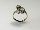 un gros plan d'une bague en argent ornée de deux fleurs