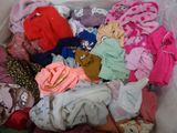 a bin full of clothes that is sitting on the floor