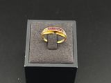 a gold ring with a red stone in the middle of it