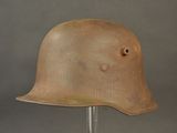 an old helmet on a metal stand against a gray background