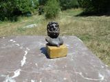 une statue représentant un lion assis sur un morceau de fromage