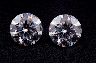 une paire de diamants ronds taille brillant sur un fond noir