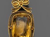 une broche en or et citrine représentant une femme portant un nœud