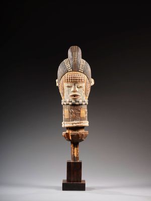 une tête d'homme sculptée posée sur un socle en bois