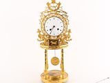 une horloge en or posée sur un socle