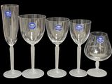 quatre verres à vin transparents sont alignés sur un fond noir